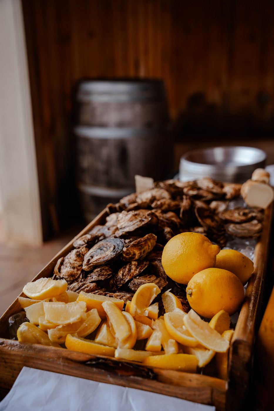 A wooden crate of unshucked oysters with lemons, ready for shucking