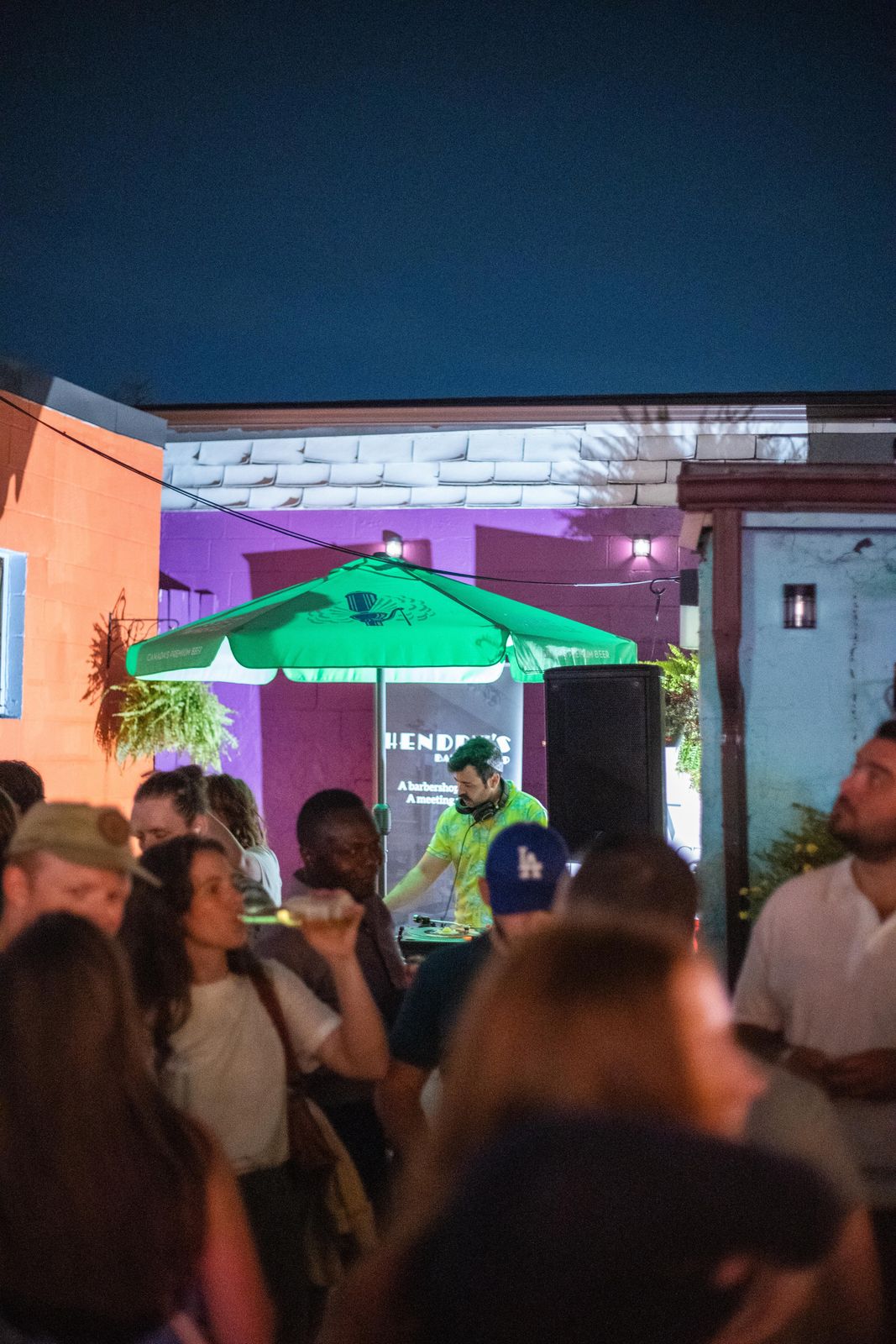 A courtyard full of people at night during Art Crawl