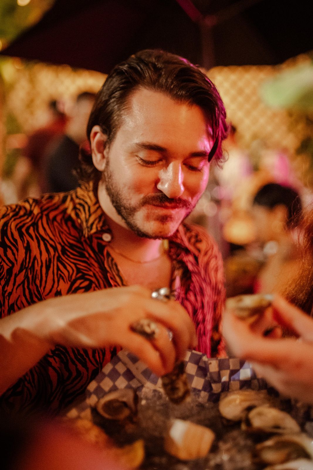 A guest eating a fresh oyster at Art Crawl