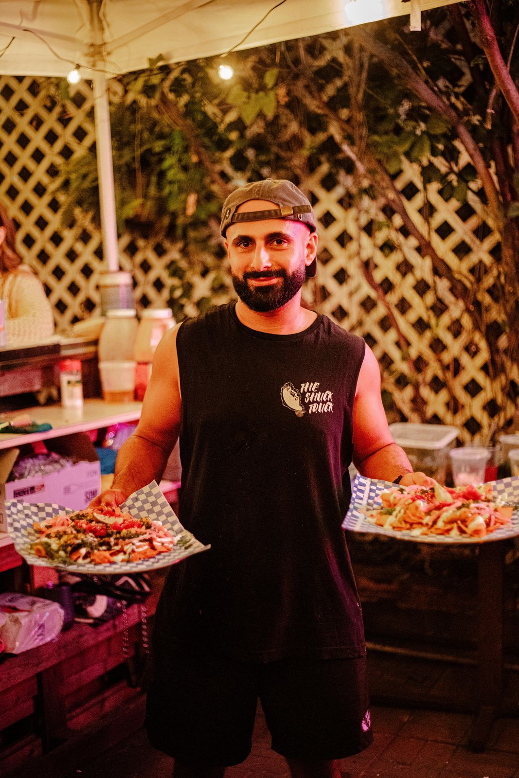 Serving two plates of seafood under the lights at Art Crawl