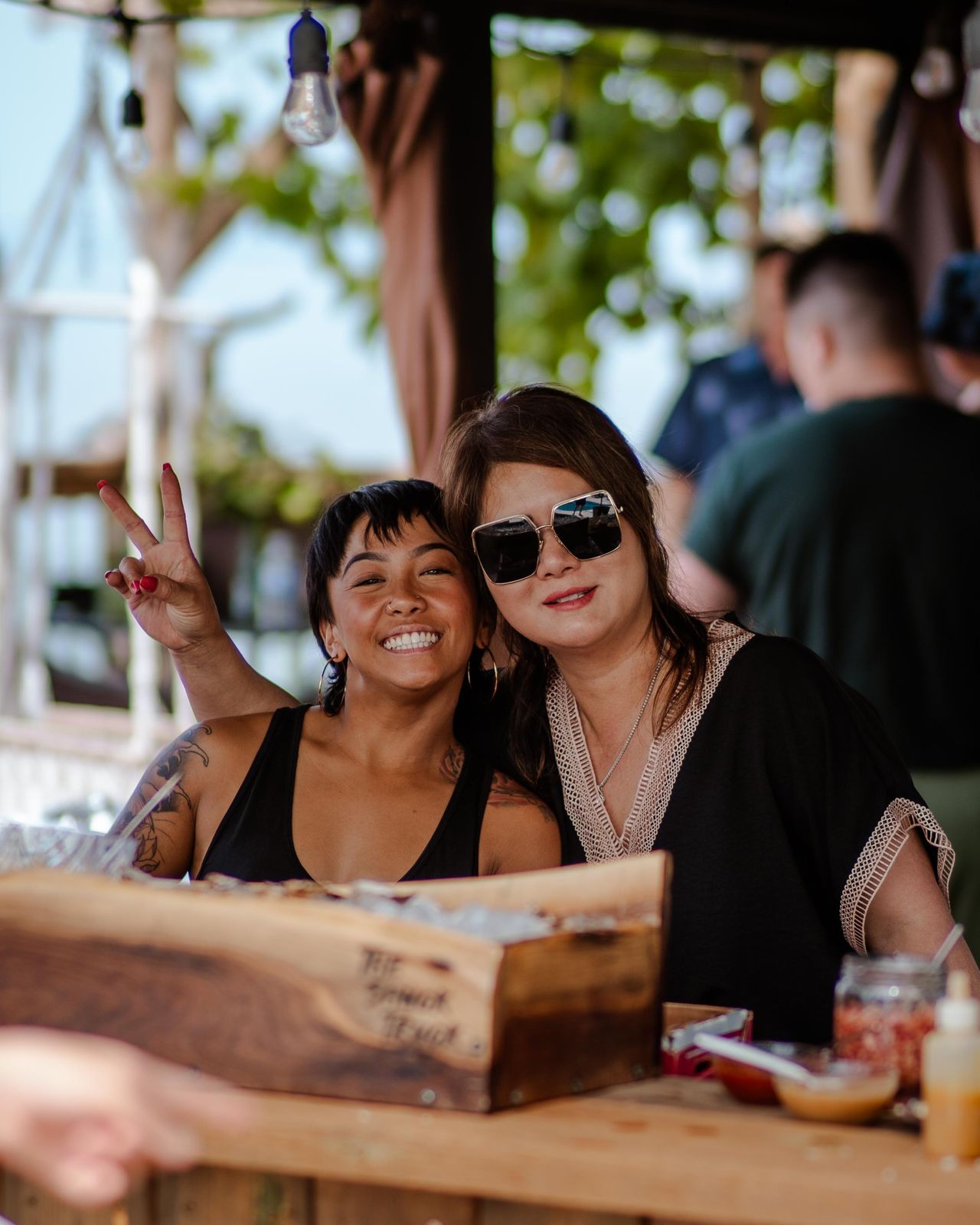 Two friends posing at the live-edge oyster box