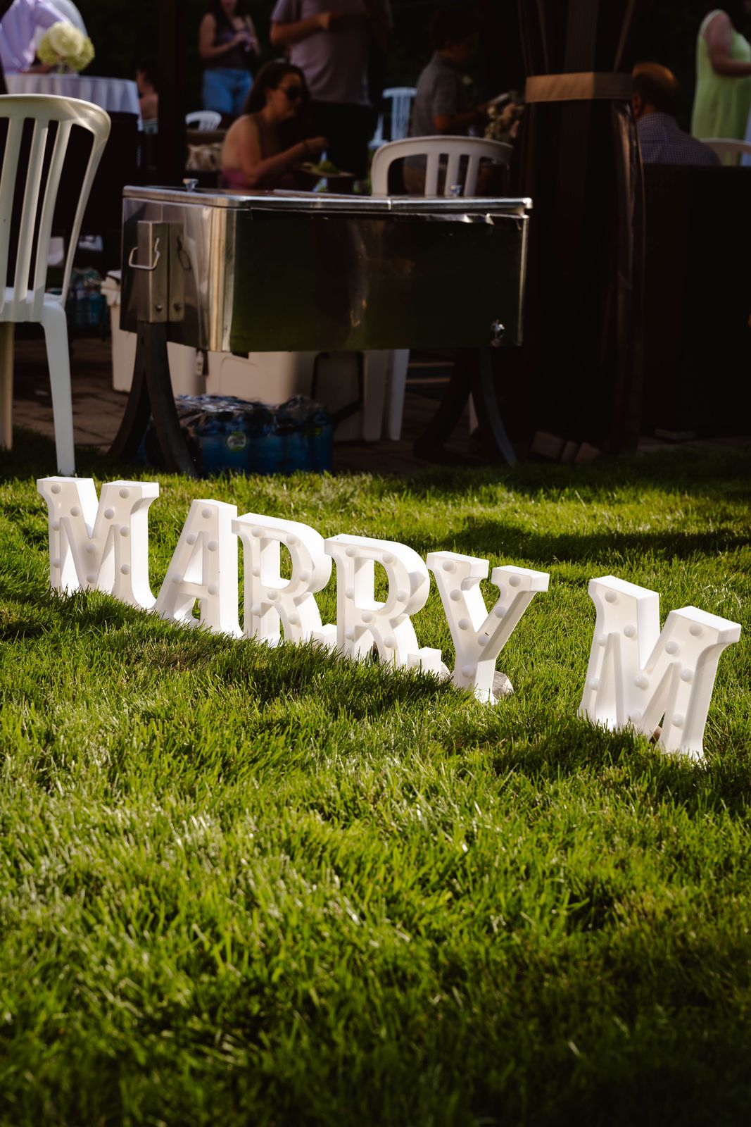 Marry Me letters on the grass at a proposal party