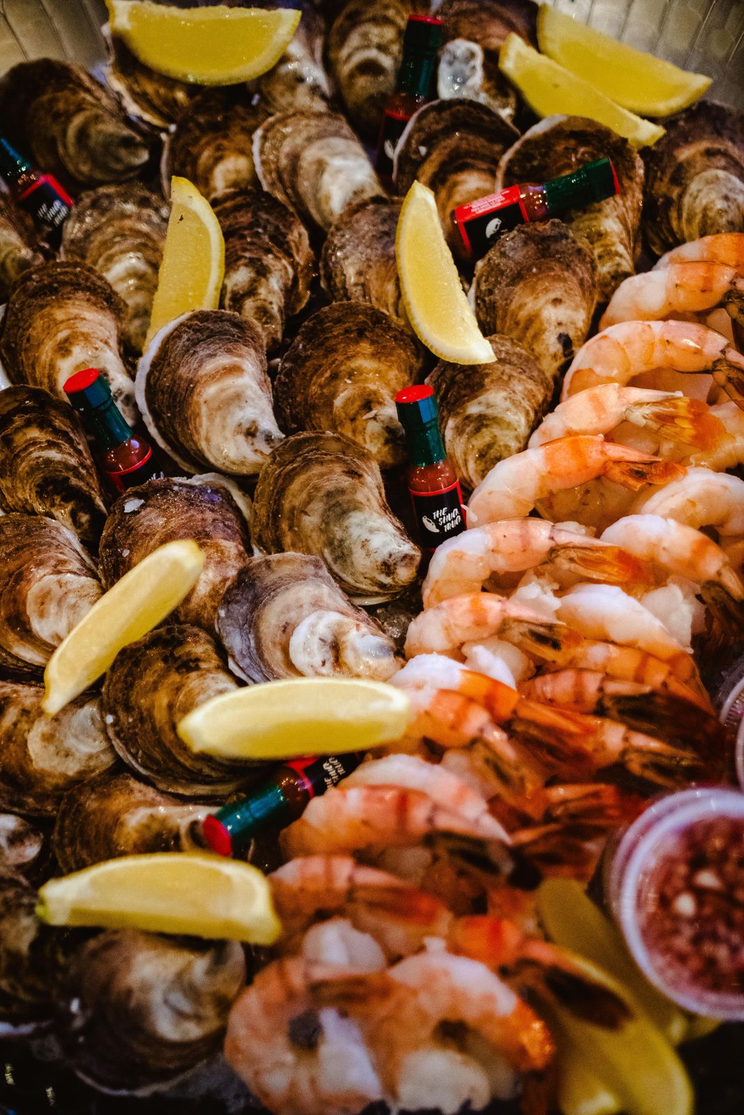 A tray of oysters and shrimp with lemon