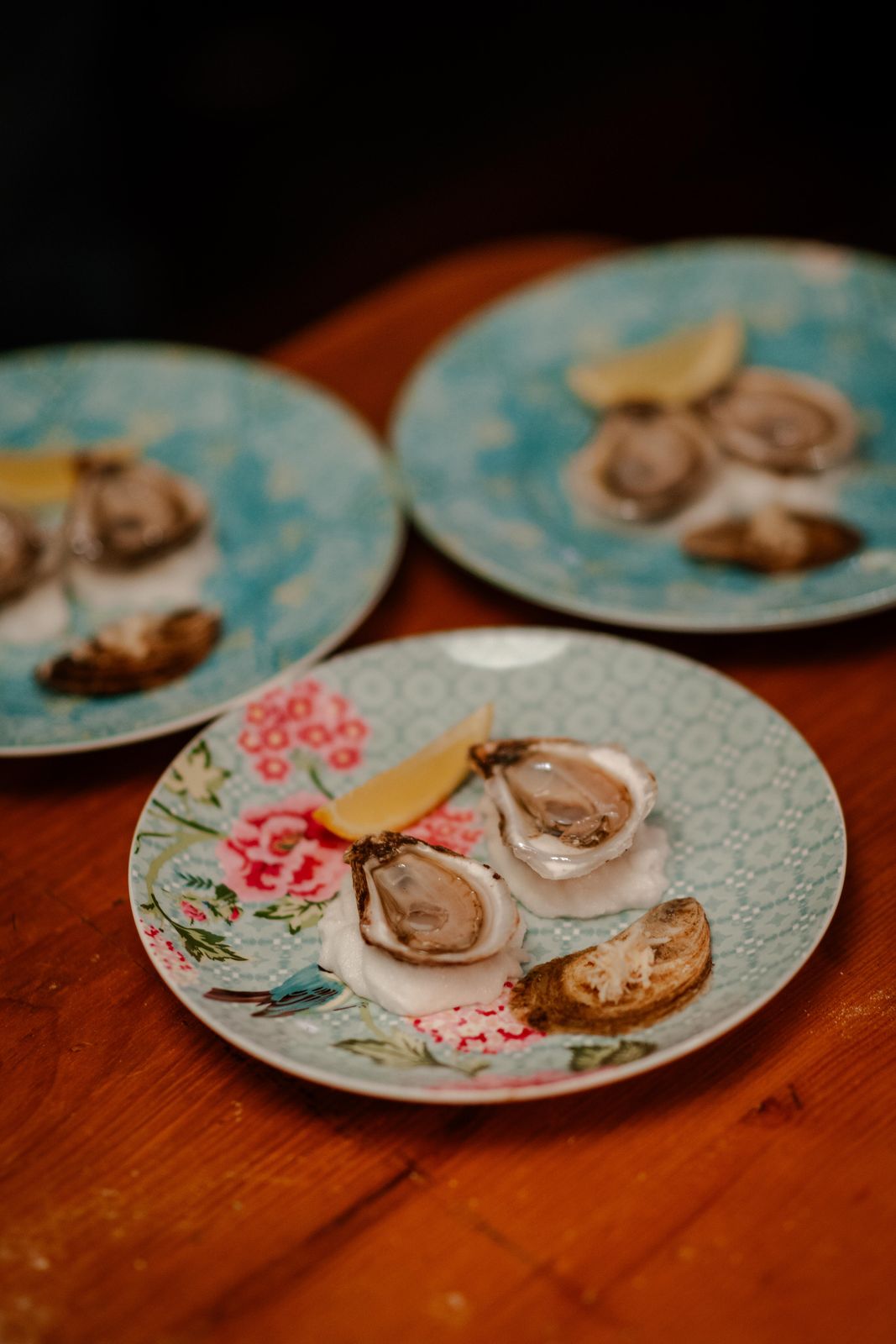 Oysters served on vintage floral plates at a private dinner