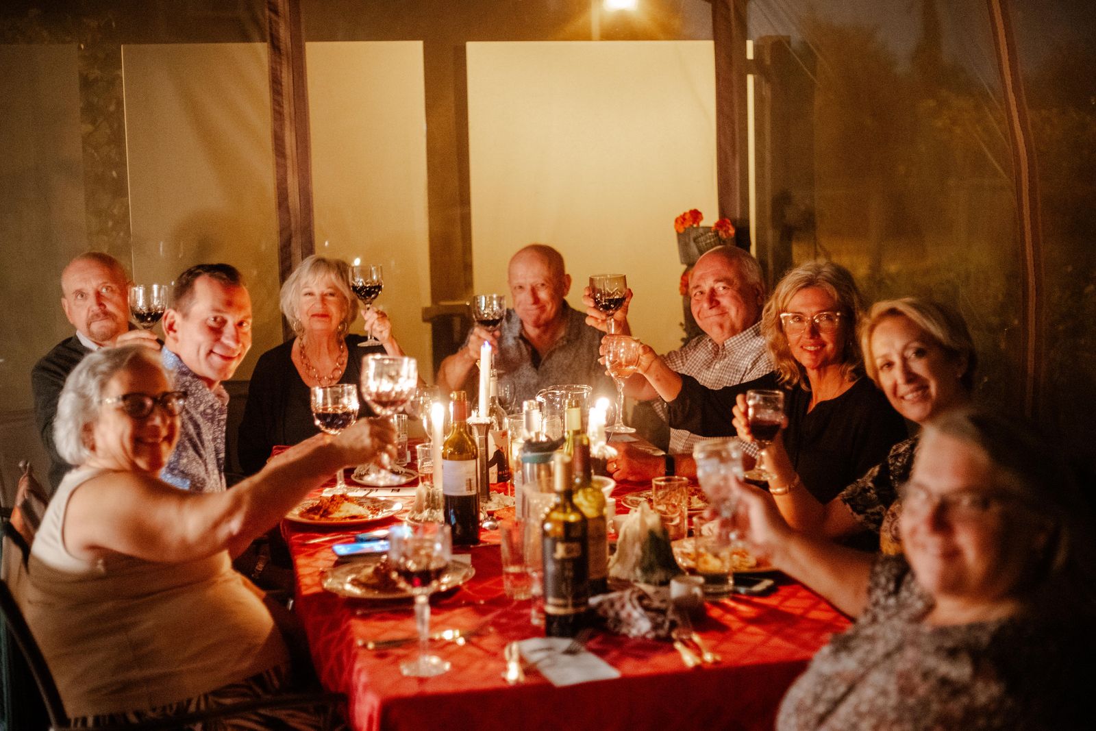 Guests around a long candlelit table at a private dinner