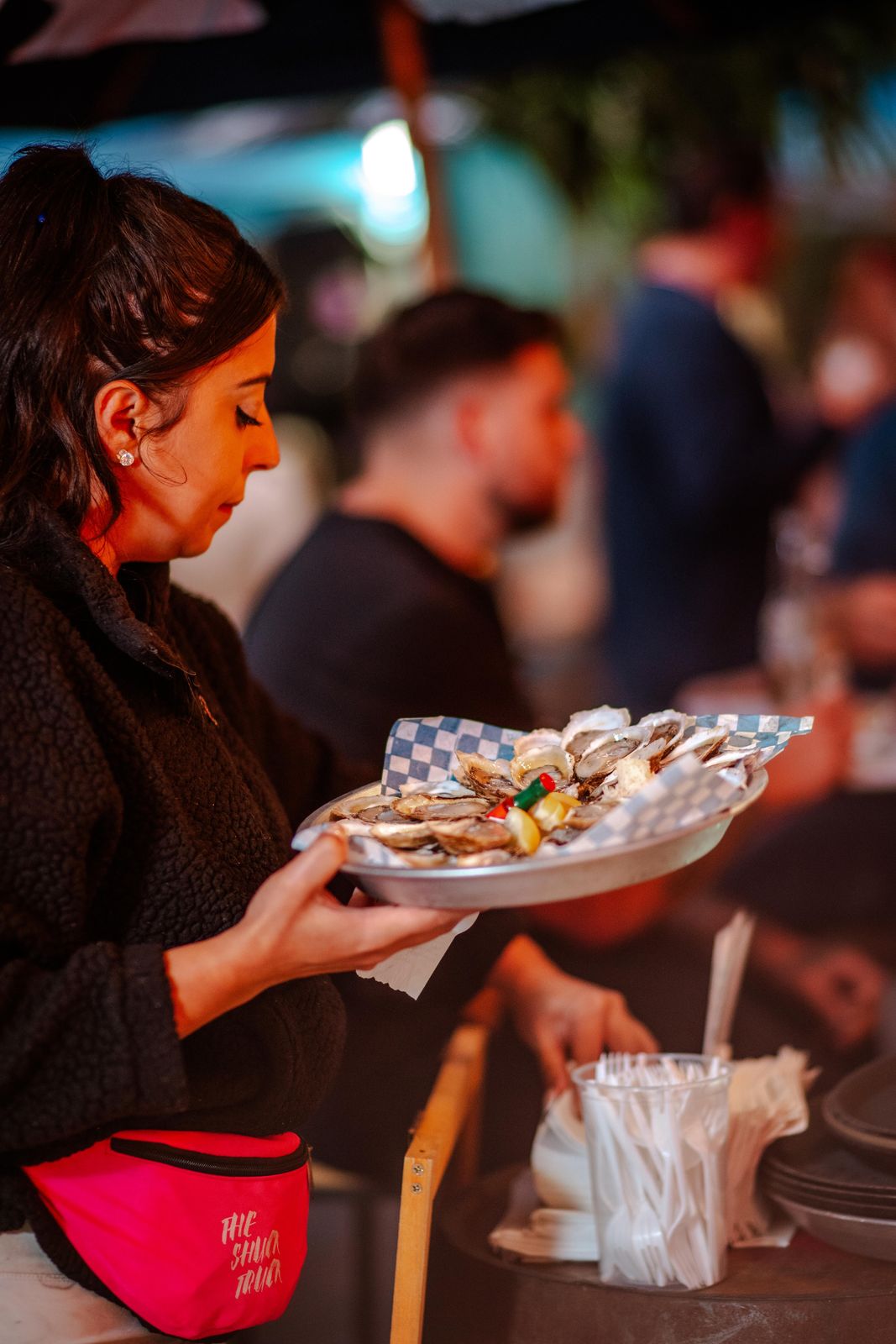 A guest carrying a plate of oysters at Supercrawl