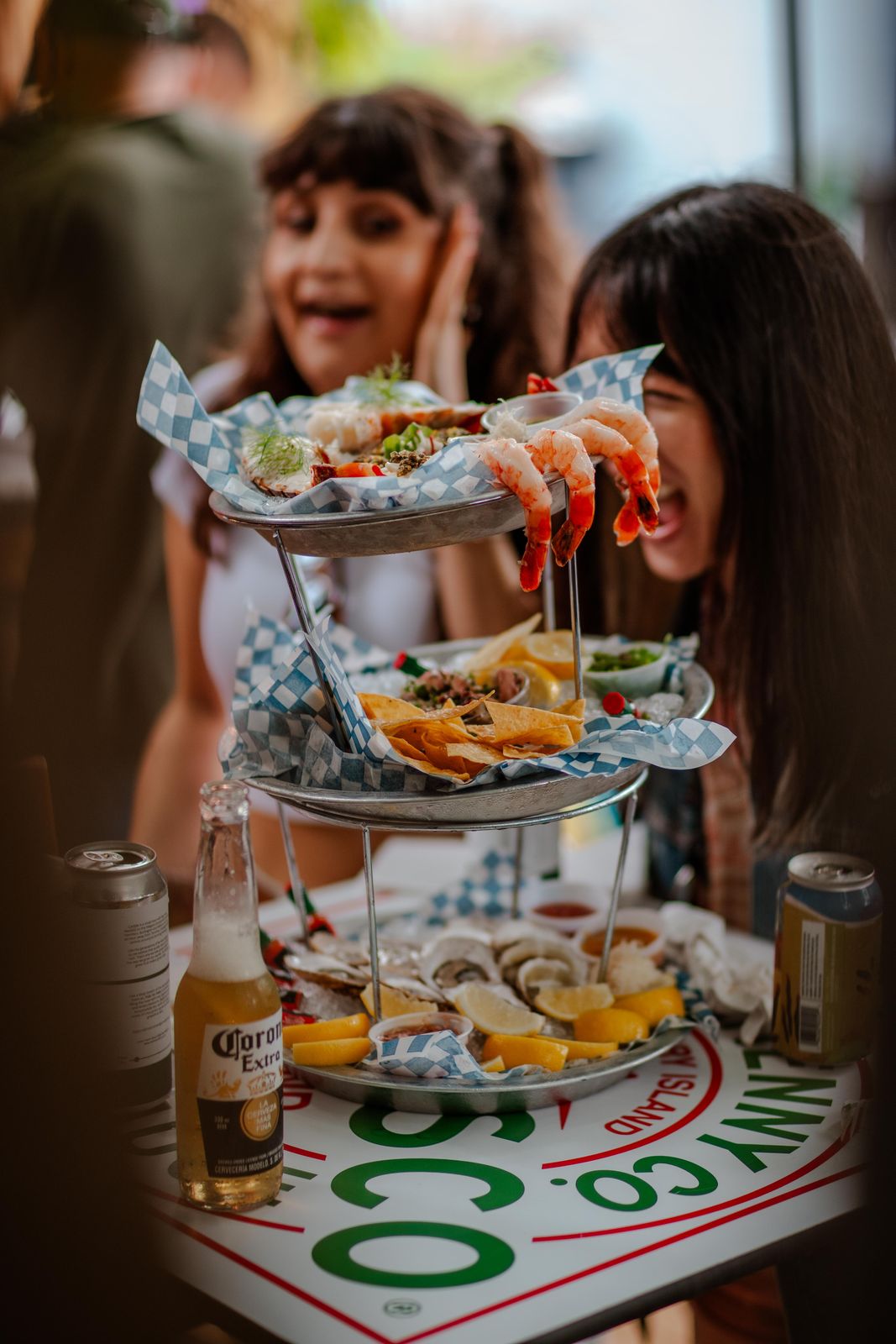 Friends reaching into a seafood tower at Supercrawl