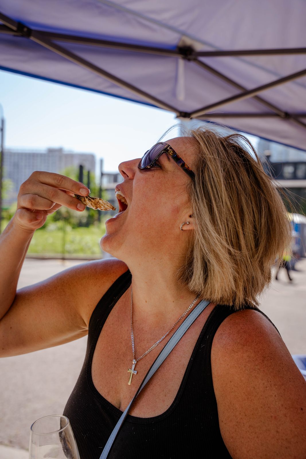 A guest tipping back an oyster at Toronto Food and Wine Fest