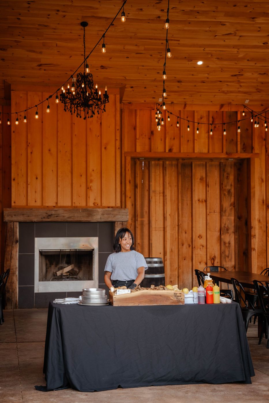 The live-edge board on a black-draped table in a timber venue hung with string lights