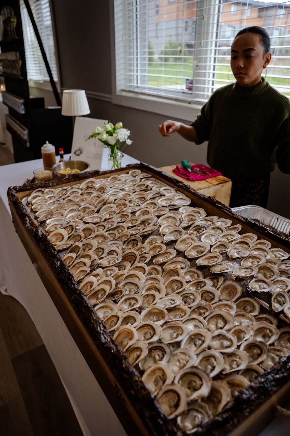 The shucker standing behind the full live-edge board at a venue